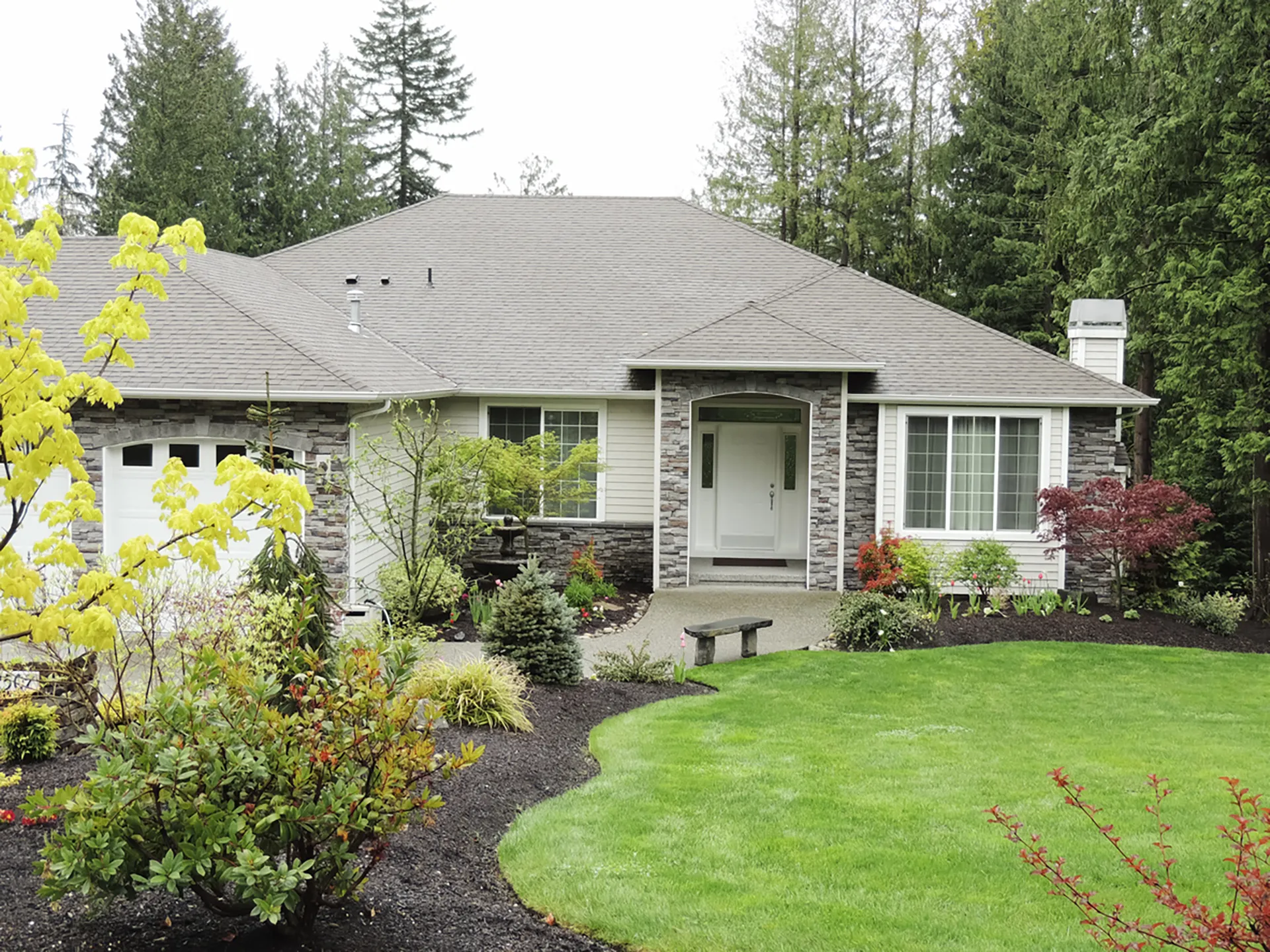 Residential home with professional lawn care and landscaping by Lawn Panther in Holly Springs NC Professional shrub and landscape installation with manicured lawn and mulch beds in Apex NC