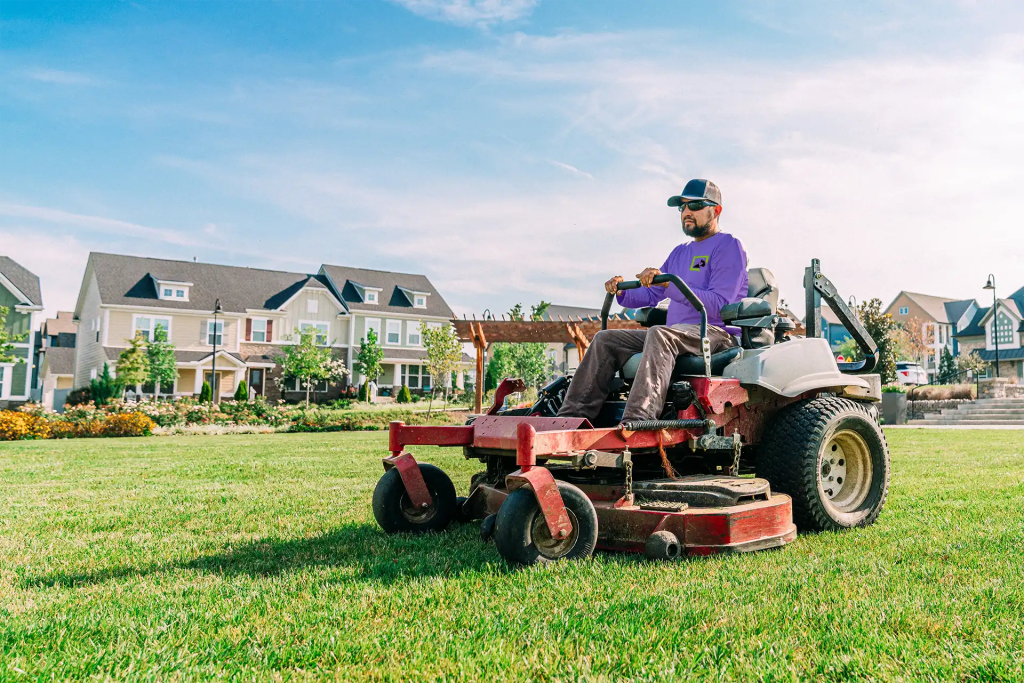 Lawn Panther crew member mowing a North Carolina lawn on a zero-turn mower